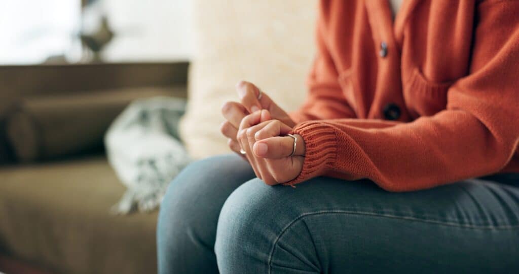 Woman stressed during addiction treatment looking at her hands