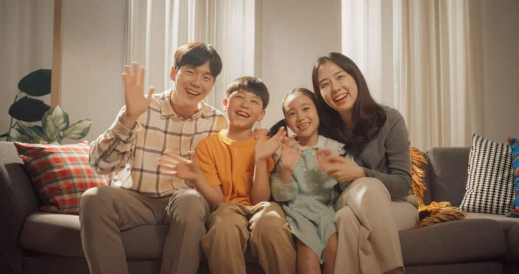 A happy, smiling family sitting together outside on a sunny day in Southern California, symbolizing healthy family dynamics and recovery from parental burnout.