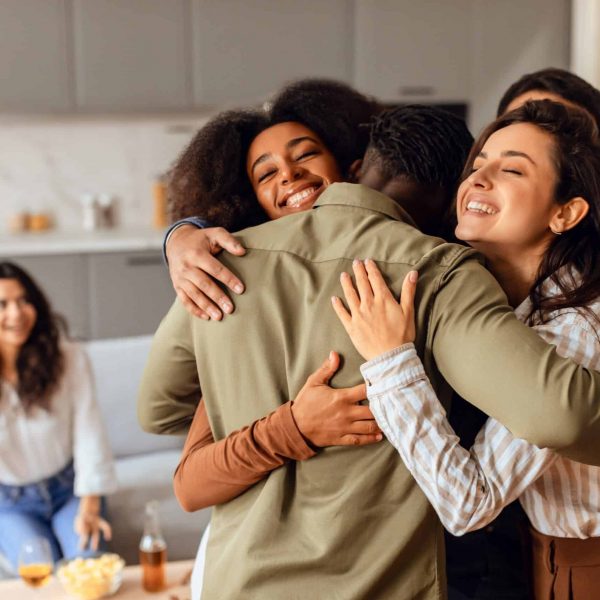 Group,Of,Diverse,Young,Friends,Sharing,Hug,During,Home,Party